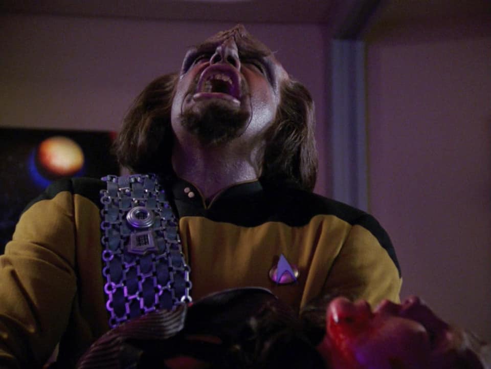 The meme features a screenshot from the TV show Star Trek: Deep Space Nine, where the character of Worf is depicted in a state of intense anger or rage. The image is captioned "When someone says 'I'm not a morning person' but you're on a space station in the middle of a war zone".